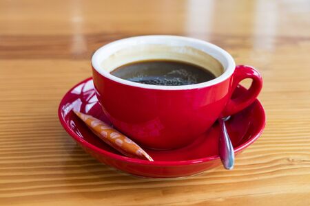 Organic black coffee Vietnam in a red cup. With spoon and sugarの写真素材
