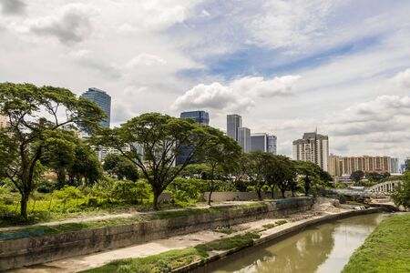 Huge skyscrapers behind tropical nature and river in Kuala Lumpur.の写真素材