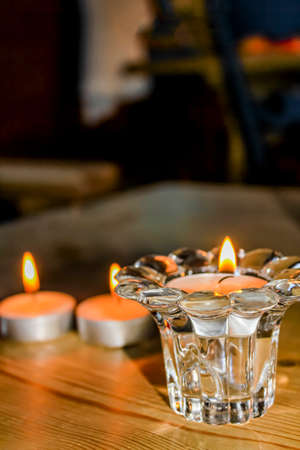 Candlelight in the glass on wooden table in Hemsedal, Norway.の写真素材