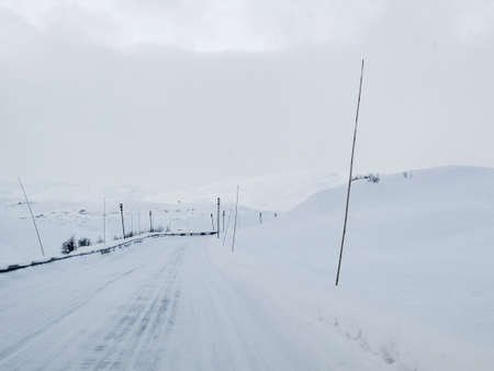 Driving through snowy white road and landscape in Norway.
