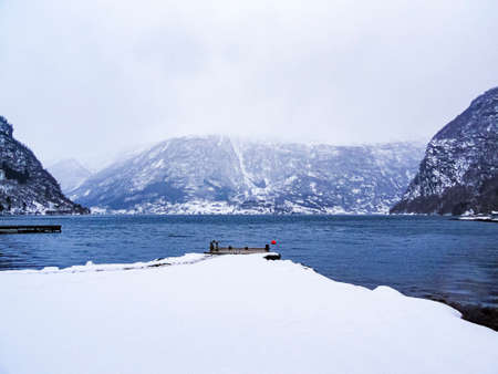 Jetty in a winter landscape at the fjord lake in Framfjorden, Vestland, Vik, Norway.の写真素材