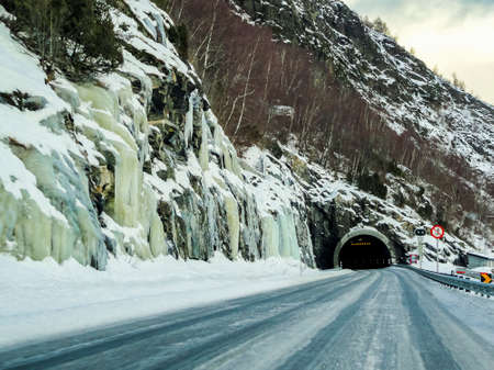 Frozen iced waterfalls and dark tunnel in the mountains and streets of Norway.