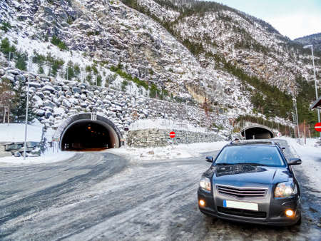 Car in front of a tunnel in winter landscape of Norway.