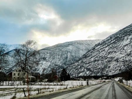 Driving through snowy white road and winter landscape in Norway.の写真素材