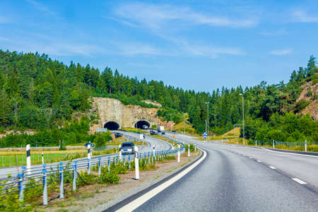 Driving through Sweden towards the tunnel and mountain in summer.
