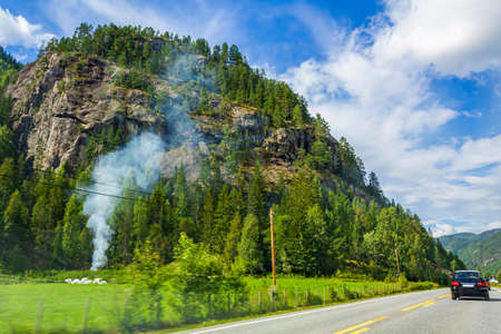 Campfire and smoke by the road side in countryside in Norway.の写真素材
