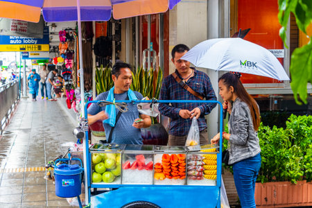Buying food and fruits at a street food stand in Bangkok Thailand.のeditorial素材