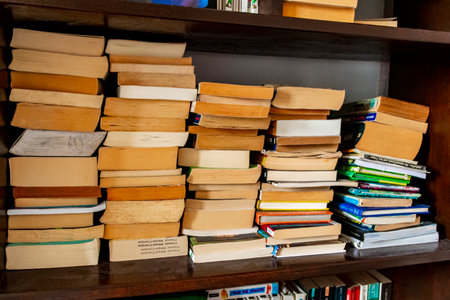 Old yellowed books stacked and tidy on the shelf in the bookcase, library.のeditorial素材
