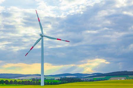 Green and calm agriculture landscapes with wind energy turbine from Germany.