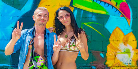 Young crazy sexy model hipster couple against colorful background tourism in Playa del Carmen Mexico.の写真素材