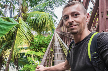 Tourist by the old French Bridge of wooden board in Luang Prabang Laos Asia.