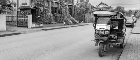 Black and white picture of an old tuk tuk rickshaw in Luang Prabang Laos.