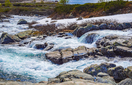 Beautiful Storebottane river by the vavatn lake with snow in the summer landscape in Hemsedal...