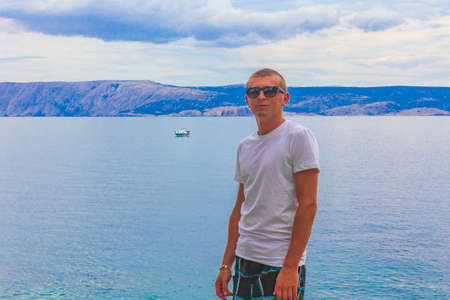 Tourist traveler young model with sunglasses wonderful turquoise and blue water and seascape at the beach in Novi Vinodolski Croatia.の写真素材