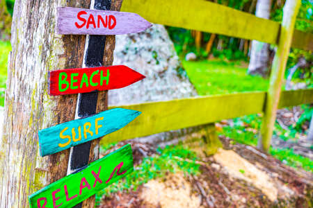 Sand beach surf and relax on colorful directional wooden arrows on the Mangrove beach and Pouso beach on tropical island Ilha Grande Rio de Janeiro Brazil.の写真素材
