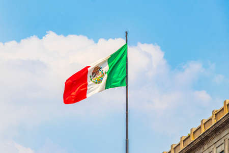 Mexican flag green white red with blue sky in the center of Mexico City in Mexico.の写真素材