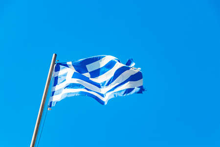 Greek blue and white flag with blue sky background on Rhodes in Greece.の写真素材