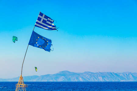Greek flag windsurfing vacation with view to Turkey on Rhodes in Greece and the beautiful clear...