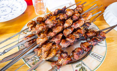 Russian shashlik with skewers on plate and wooden table in Norway.