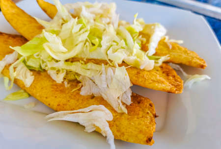 Mexican empanada with cabbage and hot sauce on white plate blue background from Playa del Carmen in Mexico.の写真素材