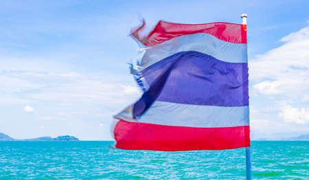 The national flag of Thailand in the rough wind and blue sky at island Koh Phayam in Ranong Thailand.の写真素材