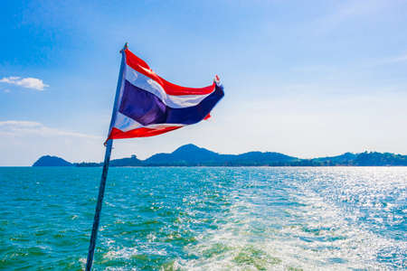 The national flag of Thailand in the rough wind and blue sky at island Koh Phayam in Ranong Thailand.の写真素材