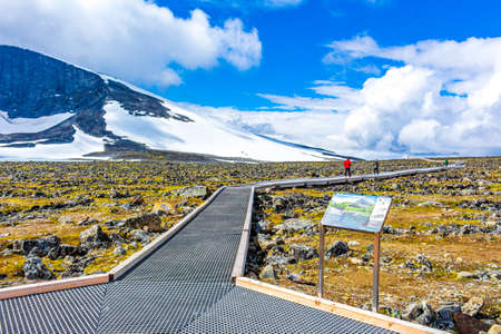 Jotunheimen Norway July 30, 2015 Hiker people on hiking trail to GaldhÃ¸piggen snow-covered mountain in summer in Jotunheimen Norway. The highest mountain in Norway and Scandinavia.のeditorial素材