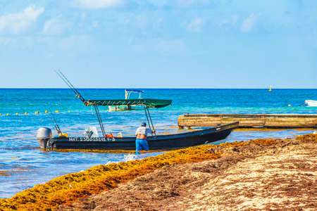Playa del Carmen Mexico August 5th, 2021 Boats and yachts is stuck in a lot of very disgusting red seaweed sargazo at tropical mexican beach in Playa del Carmen Mexico.のeditorial素材