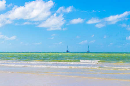Panorama landscape view on beautiful Holbox island beach with waves boats yachts and turquoise water in Quintana Roo Mexico.の写真素材