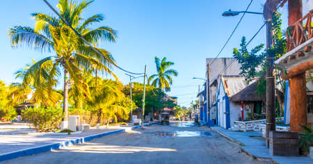 Holbox Mexico December 22, 2021 Colorful village on beautiful Holbox island with restaurant store vehicles people and mud in Quintana Roo Mexico.のeditorial素材