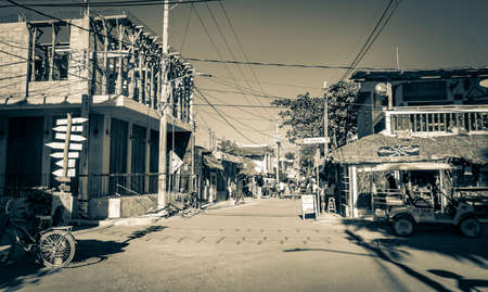 Holbox Mexico December 22, 2021 Black and white picture of the colorful village on beautiful Holbox island with restaurant store vehicles people and mud in Quintana Roo Mexico.のeditorial素材
