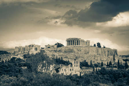 Black and white picture of Acropolis of Athens on hill with amazing and beautiful ruins Parthenon and blue cloudy sky in Greece's capital Athens in Greece.の写真素材