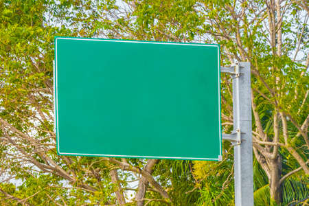 Green turquoise blank empty road sign at the highway in the city of Playa del Carmen Quintana Roo Mexico.の写真素材