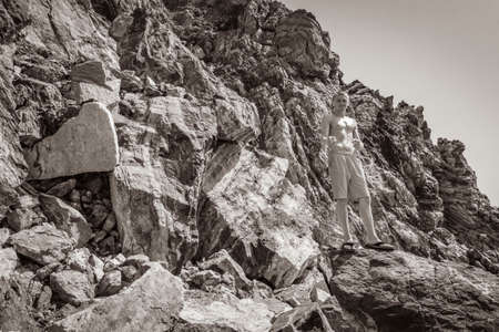 Black and white picture of a young traveler hiker with natural coastal landscapes on Kos Island in Greece with mountains cliffs rocks turquoise blue beaches and waves.の写真素材