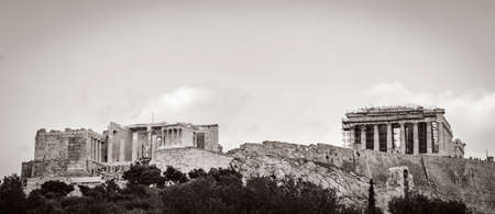 Black and white picture of Acropolis of Athens on hill with amazing and beautiful ruins Parthenon and blue cloudy sky in Greece's capital Athens in Greece.の写真素材