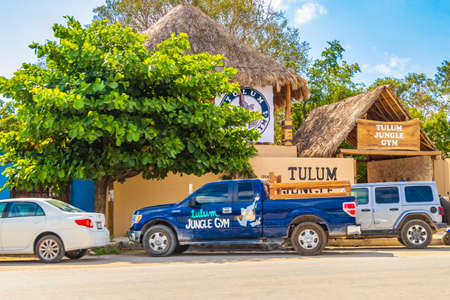 Tulum Mexico February 02, 2022 Driving thru typical colorful street road and cityscape with cars traffic palm trees bars and restaurants of Tulum in Mexico.のeditorial素材