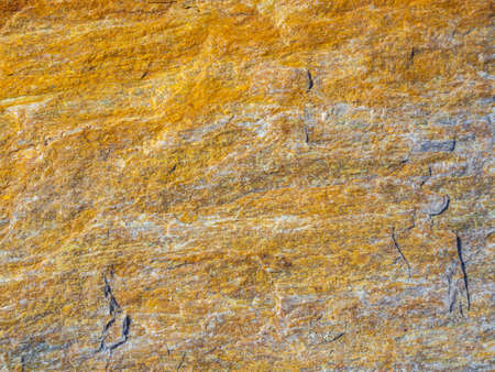 Stone rock wall texture with orange and yellow moss and lichen colors in Hemsedal Norway.