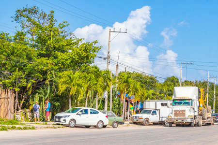 Tulum Mexico February 02, 2022 Trucks dump truck excavator and other industrial vehicles on typical street road and cityscape in Tulum in Mexico.のeditorial素材