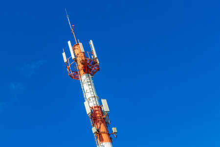 Red white 5G tower with blue sky background radiation kills us in Playa del Carmen in Mexico.