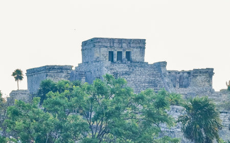 Ancient Tulum ruins Mayan site with temple ruins pyramids and artifacts in the tropical natural jungle forest palm and seascape panorama view in Tulum Mexico.のeditorial素材