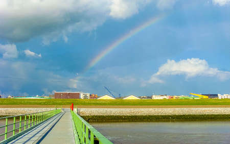 Cityscape rainbow and coast panorama of ATLANTIC Hotel Sail City lighthouse ships architecture boats dike and landscape of Bremerhaven in Germany.の写真素材