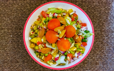 Bowl of healthy salad food with greens cucumber tomato garlic broccoli carrots onion in Playa del...