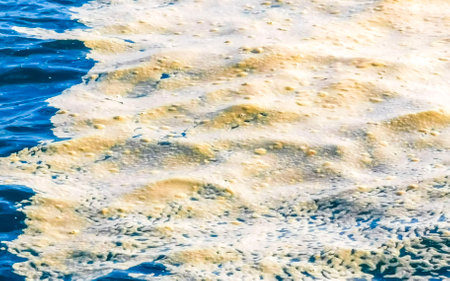 Yellow foam in turquoise blue water with waves in Puerto Escondido Zicatela Oaxaca Mexico.の写真素材