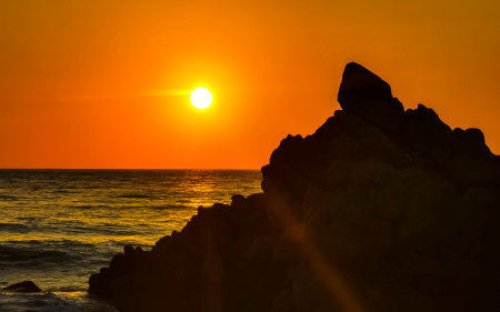 Beautiful stunning colorful and golden sunset in yellow orange red on beach and big wave panorama in tropical nature in Zicatela Puerto Escondido Oaxaca Mexico.の写真素材