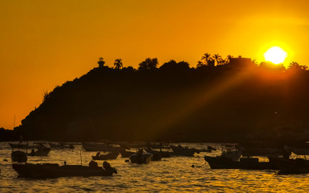 Beautiful stunning colorful and golden sunset in yellow orange red on beach and big wave panorama in tropical nature in Zicatela Puerto Escondido Oaxaca Mexico.の写真素材