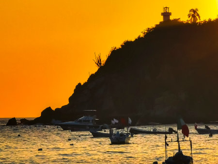 Beautiful stunning colorful and golden sunset in yellow orange red on beach and big wave panorama in tropical nature in Zicatela Puerto Escondido Oaxaca Mexico.の写真素材