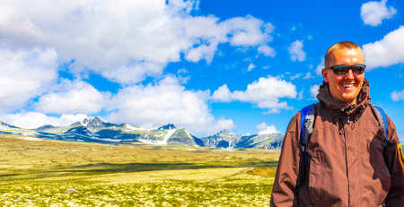 Young hiker and beautiful summer landscape panorama with mountains river lake rocks and hiking trail...
