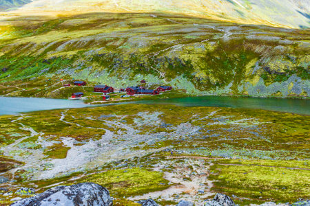 Beautiful mountain and landscape panorama with untouched nature rivers lakes rocks stones and red huts houses in Rondane National Park Ringbu Innlandet Norway in Scandinavia.の写真素材
