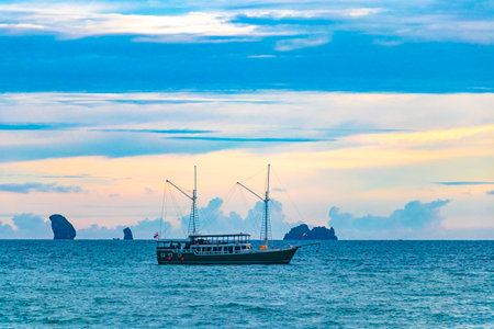 Beautiful colorful golden sunset and tropical paradise panorama view on turquoise water beach and between limestone rocks on Ao Nang Beach in Amphoe Mueang Krabi Thailand in Southeast Asia.の写真素材
