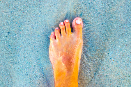 Walking barefoot on the beach sand by the water in Playa del Carmen Quintana Roo Mexico.の写真素材